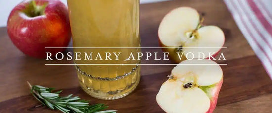 Manzanas cortadas y ramas de romero fresco listas para macerar con alcohol etílico de alta pureza.