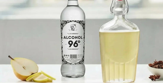 Pera cortada y estrellas de anís junto a botella de alcohol LICORERO para elaborar licor artesano.