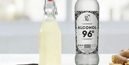 Raíz de jengibre fresca junto a botella de alcohol etílico certificado para licores caseros.