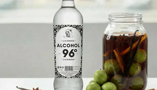 Frasco de ratafia artesanal macerando con nueces verdes, canela y hierbas aromáticas.